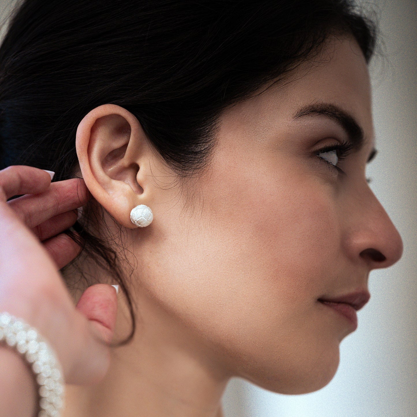 Modelo de perfil mostrando pendientes de filigrana en plata 950 con diseño tradicional de Santa Fe de Antioquia, resaltando la belleza y elegancia de este juego de joyería