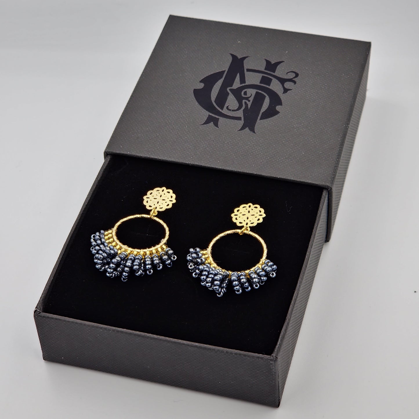 Aretes medianos de rodio con shakiras azules, elaborados artesanalmente con un diseño elegante y cómodo, ideales para cualquier ocasión con un toque de frescura.