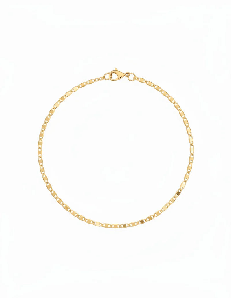 Woman wearing 18k gold filled flat ladder anklet, 25cm diamond-cut gold chain, waterproof luxury jewelry, hypoallergenic, beach-ready ankle bracelet.