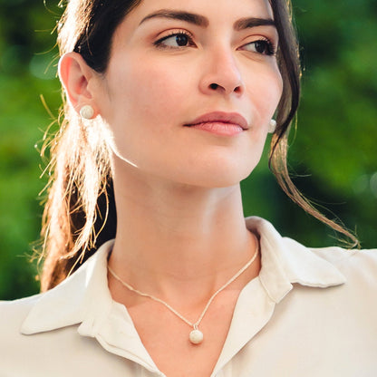 Modelo profesional y elegante en Estados Unidos usando un juego de joyería en plata 925 con diseño de filigrana y el emblemático nudo de Santa Fe de Antioquia, combinando tradición colombiana con estilo moderno.