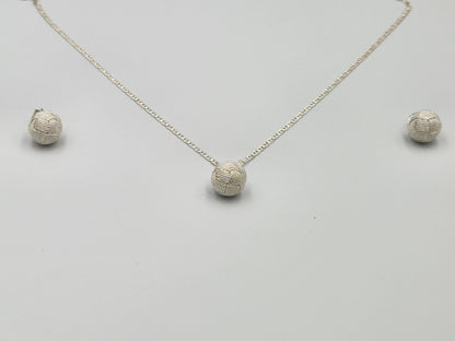 Profesional y elegante en fondo blanco luciendo un juego de joyería en plata 950 con diseño de filigrana y el nudo tradicional de Santa Fe de Antioquia, ideal para destacar en el mercado de Estados Unidos