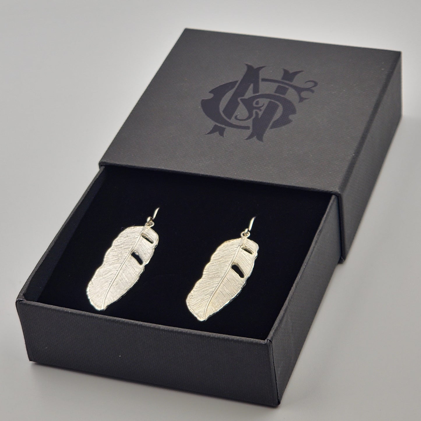 Aretes artesanales en plata 925 con forma de hoja de plátano, elaborados en Santa Fe de Antioquia con técnica de fundición y diseño naturalista