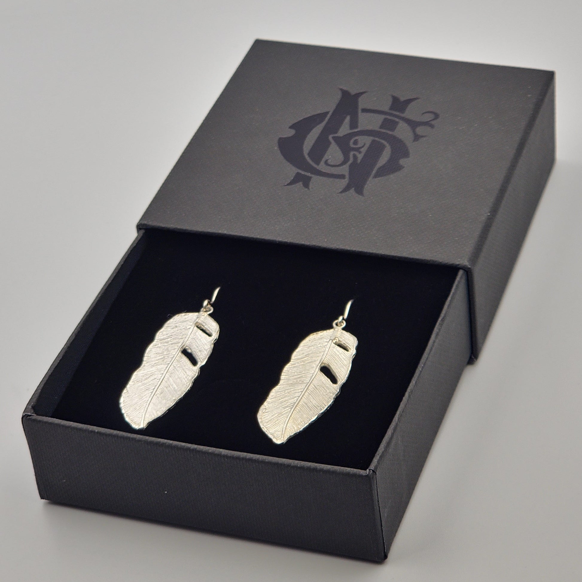 Aretes artesanales en plata 925 con forma de hoja de plátano, elaborados en Santa Fe de Antioquia con técnica de fundición y diseño naturalista