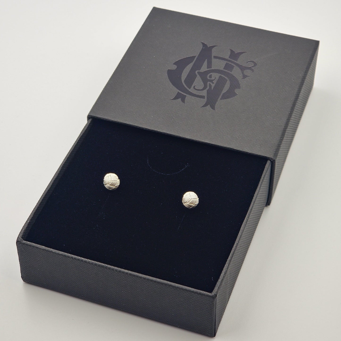 Topos de filigrana en plata 925 con forma de flor, inspirados en tejidos típicos de Santa Fe de Antioquia, presentados en caja elegante negra